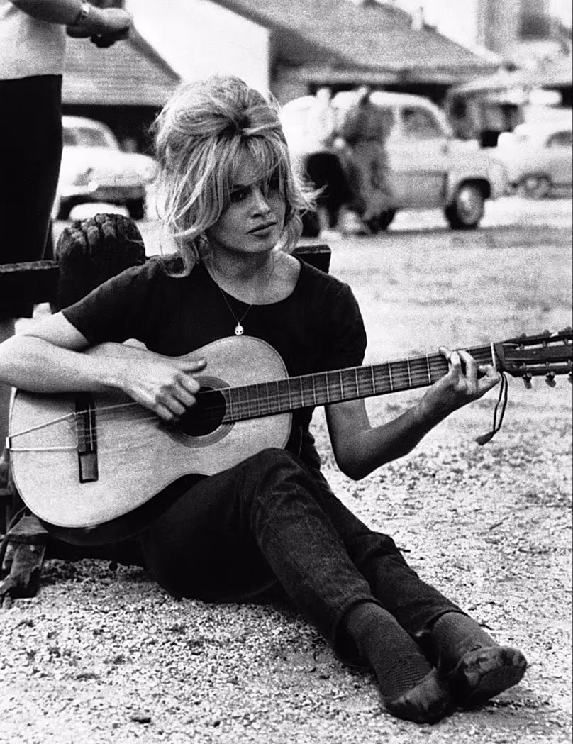 DOSSIER : L'actrice française Brigitte Bardot gratte une guitare espagnole dans les studios de cinéma de Boulogne, en France, le 17 août 1960.