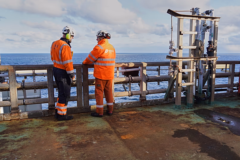 Des travailleurs se tiennent devant la balustrade de la plate-forme Siri d'INEOS Energy, dans la mer du Nord, au Danemark.