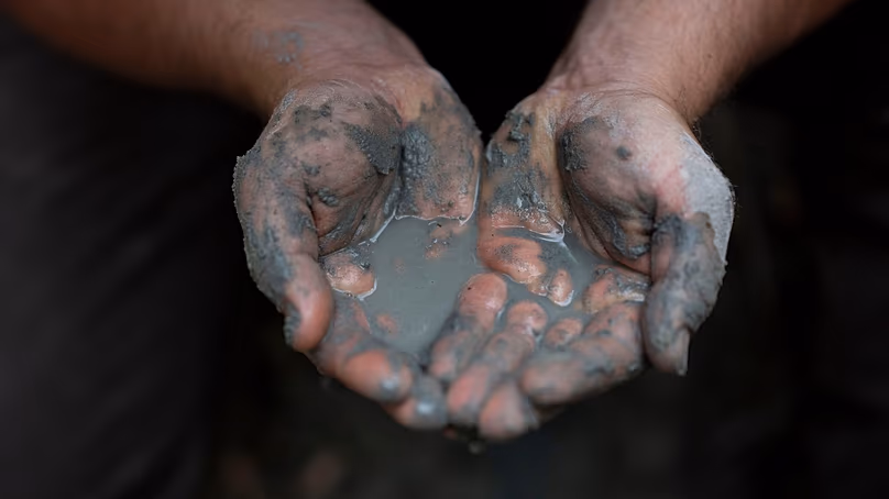 Oszkár Nagyapáti, agriculteur et membre du groupe bénévole des gardiens de l'eau, tient de l'eau dans ses mains à Kiskunmajsa, Hongrie, le 29 juillet 2025.