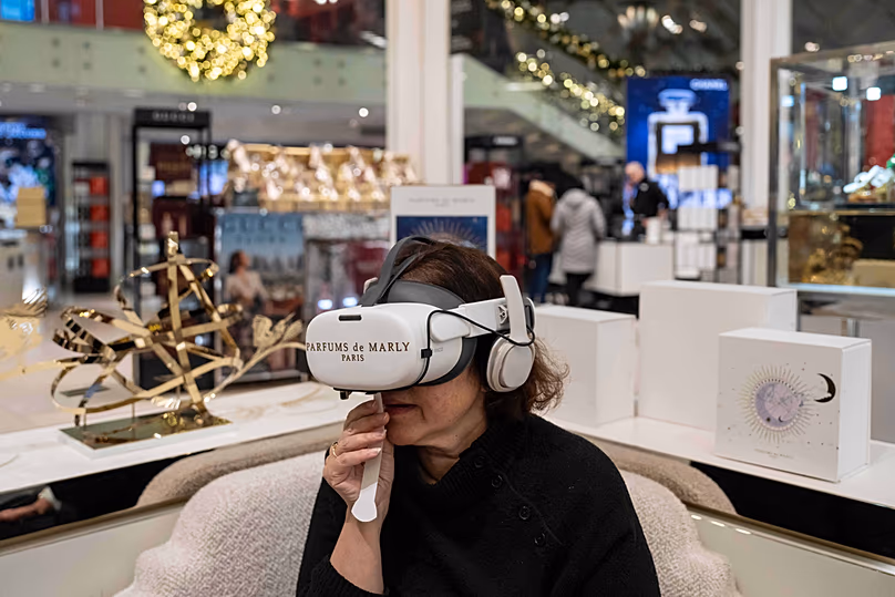 La journaliste d'Associated Press Anne D'Innocenzio sent du parfum en utilisant un casque VR de Parfum de Marly Paris dans le magasin phare de Macy's, le 21 novembre 2025, à New York.