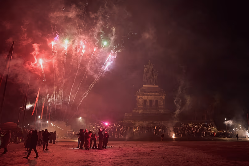 Des visiteurs déclenchent des feux d'artifice du Nouvel An devant la statue équestre de l'empereur Guillaume à Coblence, le 1er janvier 2026.