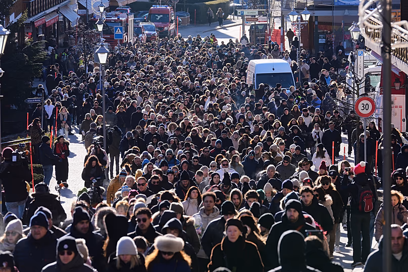 Des gens marchent lors d'une procession commémorative à Crans-Montana, dans les Alpes suisses, en Suisse, le dimanche 4 janvier 2026, après un incendie dévastateur dans le bar Le Constellation.