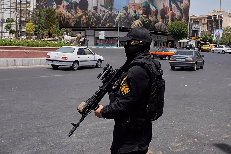 Un membre des Gardiens de la révolution iraniens se tient dans le centre-ville de Téhéran, le 24 juin 2025.