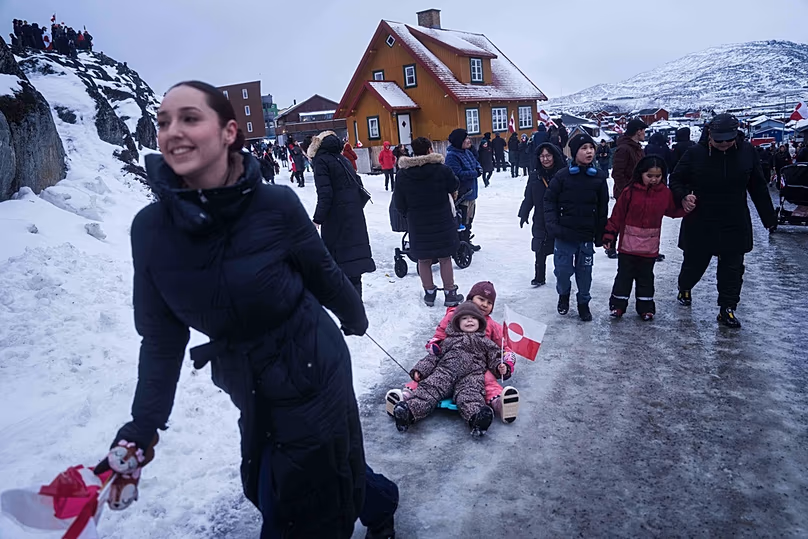 Une femme tire ses enfants sur un traîneau lors d'une manifestation contre la politique de Trump envers le Groenland devant le consulat américain à Nuuk, au Groenland, le samedi 17 janvier 2026.