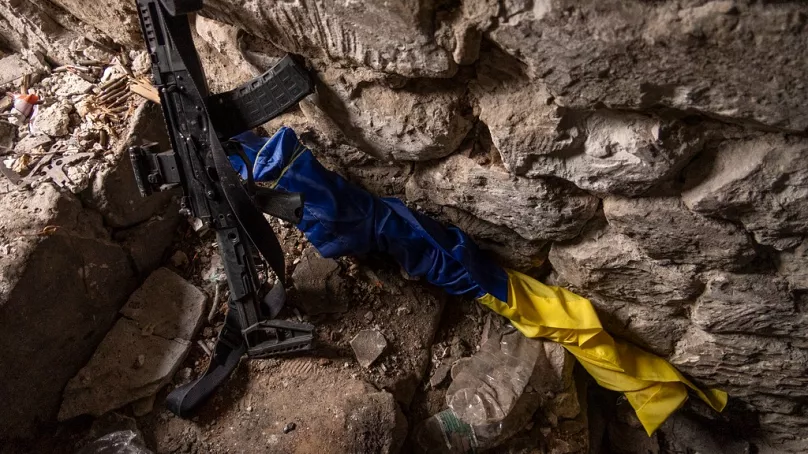 Un drapeau ukrainien à côté d'un fusil dans un bunker sur une position de première ligne à Andrijiwka le 16 septembre 2023