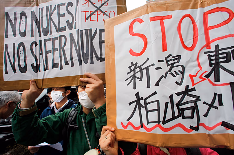 Des manifestants brandissent des pancartes lors d'un rassemblement contre la production d'énergie nucléaire devant le siège de TEPCO à Tokyo, le 3 avril 2011.