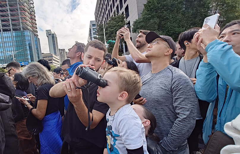 Une foule de badauds au pied du bâtiment regarde Alex Honnold escalader le gratte-ciel Taipei 101 le 25 janvier 2026.
