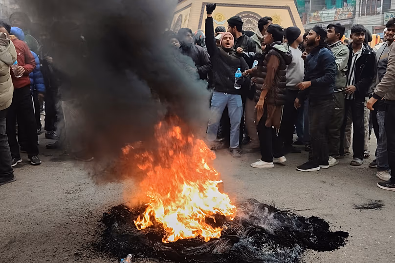 Des manifestants crient des slogans et brûlent des pneus alors qu'ils bloquent la rue principale de Birgunj, le 4 janvier 2026.