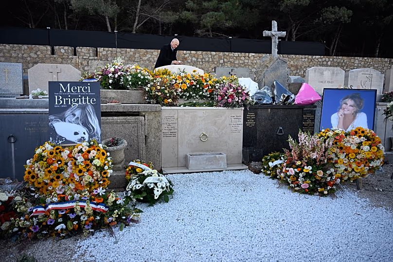 Un homme prend une photographie de la tombe de l'actrice Brigitte Bardot au cimetière de Saint-Tropez, le 7 janvier 2026.