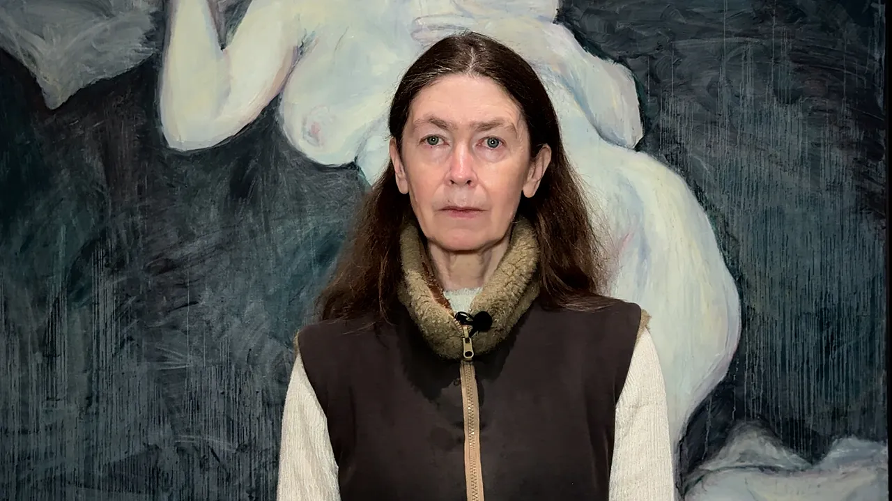 Celia Paul devant son tableau 'Fantôme d'une fille avec un œuf' qui peut être vu jusqu'au 3 mai 2026 au Musée d'Art Moderne de Varsovie.