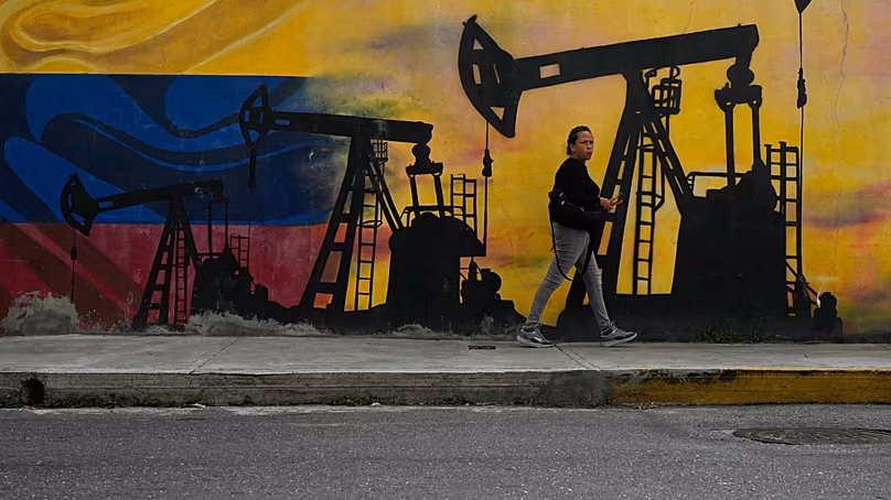 DOSSIER – Un habitant passe devant une fresque murale représentant des pompes à pétrole et des puits à Caracas, Venezuela, le 6 janvier 2026.