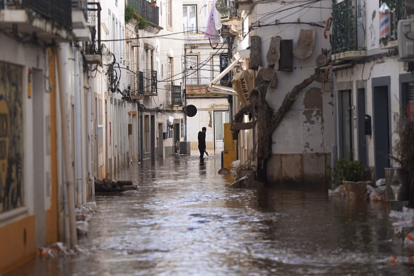 Un habitant marche le long d'une rue inondée après le débordement du fleuve Sado suite à de fortes pluies à Alcácer do Sal, dans le sud du Portugal, le vendredi 6 février 2026.