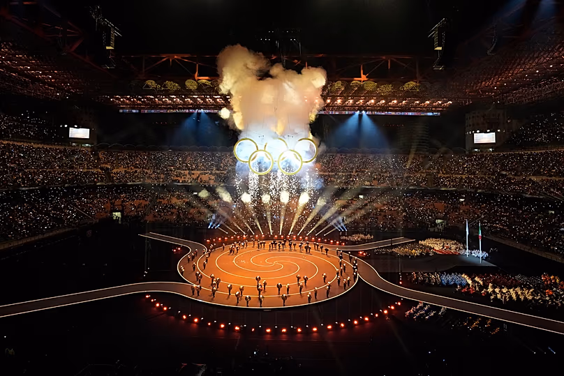 Des feux d'artifice explosent près des anneaux olympiques lors de la cérémonie d'ouverture des Jeux olympiques d'hiver de 2026, à Milan, en Italie, le vendredi 6 février 2026.