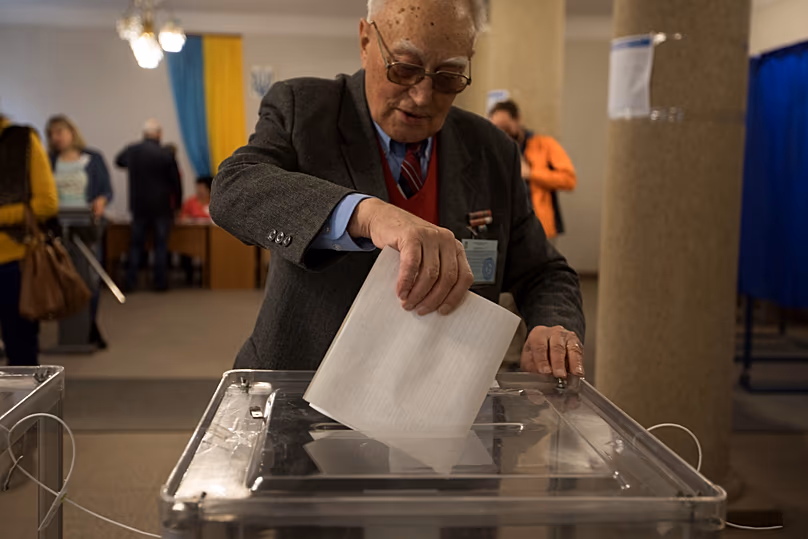 Un homme dépose son bulletin de vote dans un bureau de vote lors des élections présidentielles à Kiev, le 31 mars 2019.