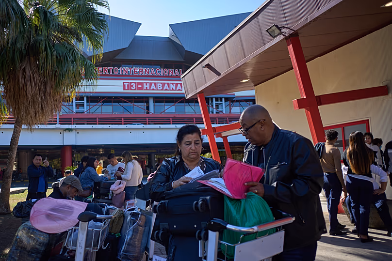 Des gens regardent leurs documents de voyage à l'aéroport international José Marti de La Havane, Cuba, le lundi 9 février 2026.