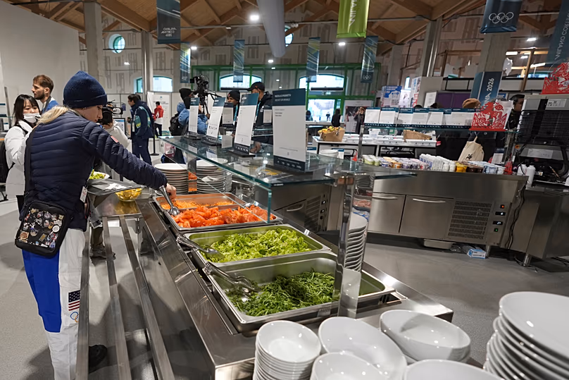Un athlète américain sélectionne des plats pour le petit-déjeuner dans la salle à manger du village olympique avant les Jeux olympiques d'hiver de 2026, à Milan, en Italie.