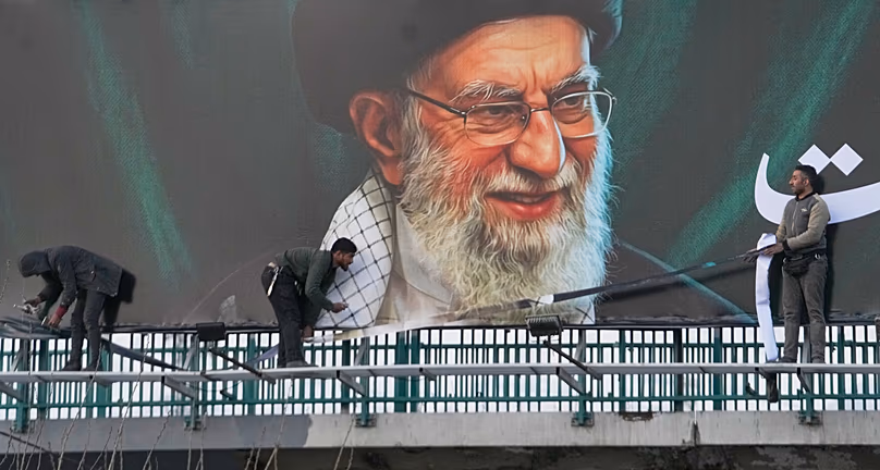 Des ouvriers installent un panneau publicitaire représentant le défunt guide suprême iranien, l'ayatollah Ali Khamenei, à Téhéran, le 2 mars 2026.