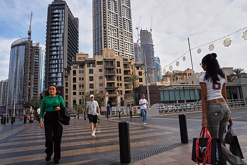 Des gens traversent une rue du centre-ville de Dubaï, le 7 mars 2026.
