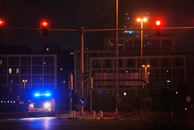 Une voiture de police bloque une rue menant au consulat américain après qu'un drone iranien a frappé un parking à l'extérieur de l'enceinte, le 4 mars 2026.
