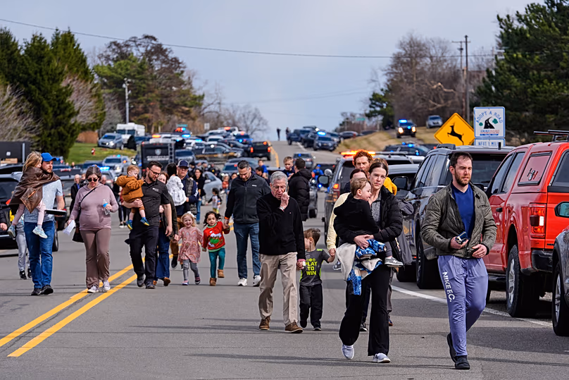 Les forces de l'ordre escortent les familles avec enfants loin de la synagogue Temple Israel le jeudi 12 mars 2026, dans le canton de West Bloomfield, Michigan.