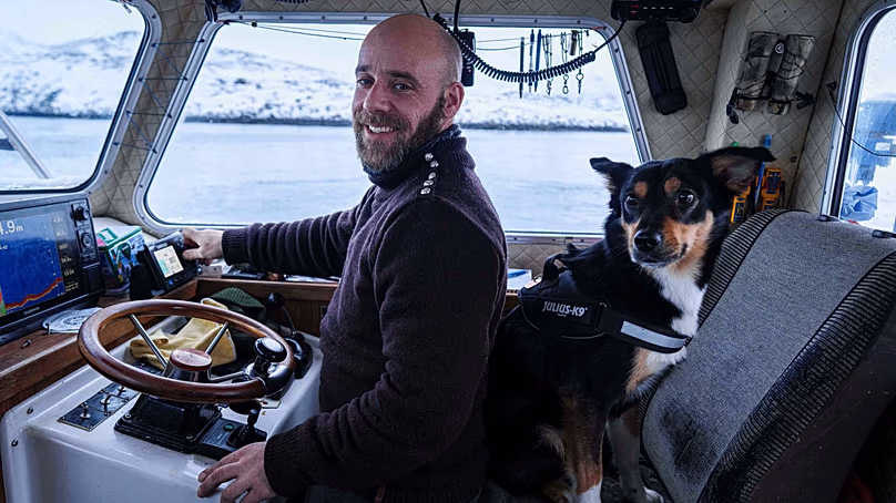 Helgi Aargil, pêcheur, avec son chien Molly, navigue sur son bateau près de Nuuk, au Groenland, le mercredi 21 janvier 2026.