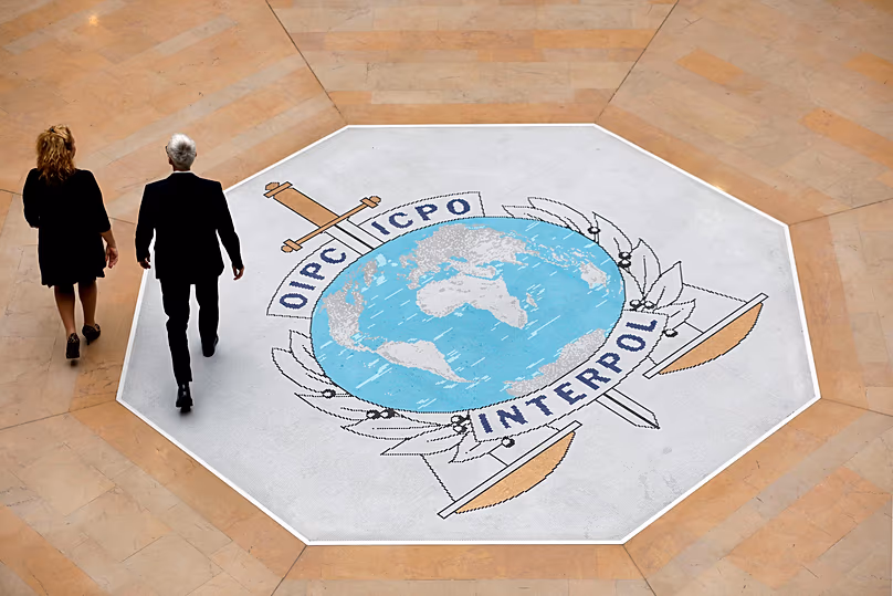 Des gens marchent sur le logo d'Interpol au siège de la police internationale à Lyon, le 8 novembre 2018.