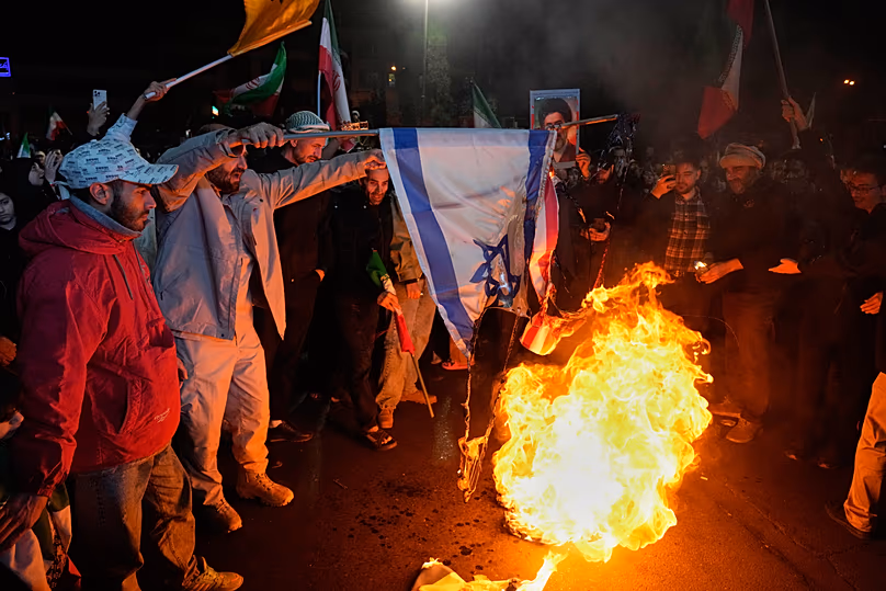 Des manifestants iraniens pro-gouvernementaux brûlent les drapeaux américain et israélien à Téhéran, le 8 avril 2026.