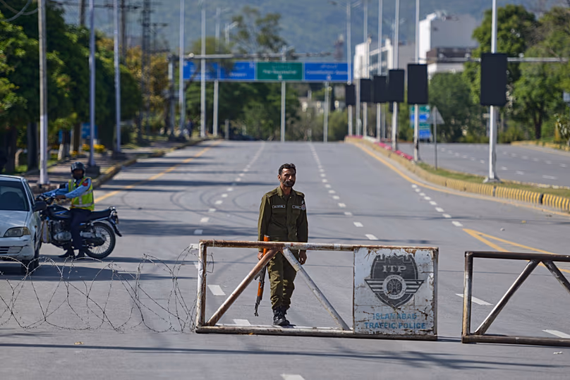 Un policier monte la garde à un point de contrôle sur une route barricadée pour assurer la sécurité avant le deuxième cycle de pourparlers américano-iraniens, Islamabad, Pakistan, dimanche 19 avril 2026.