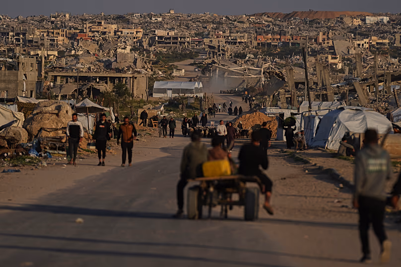 Des Palestiniens marchent dans une rue entourée de bâtiments détruits lors des opérations aériennes et terrestres israéliennes à Khan Younis, le 9 avril 2026.