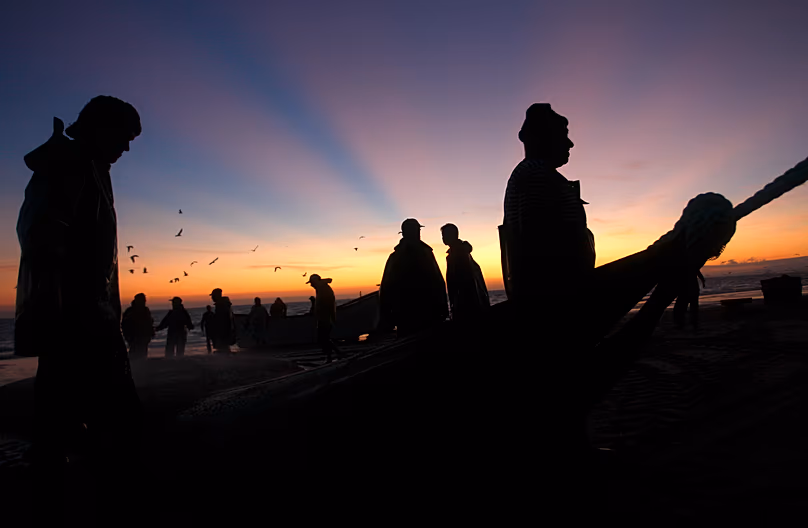 Des pêcheurs portugais sortent leurs filets de la mer et les déposent sur la plage près de Lisbonne, le 29 août 2011.