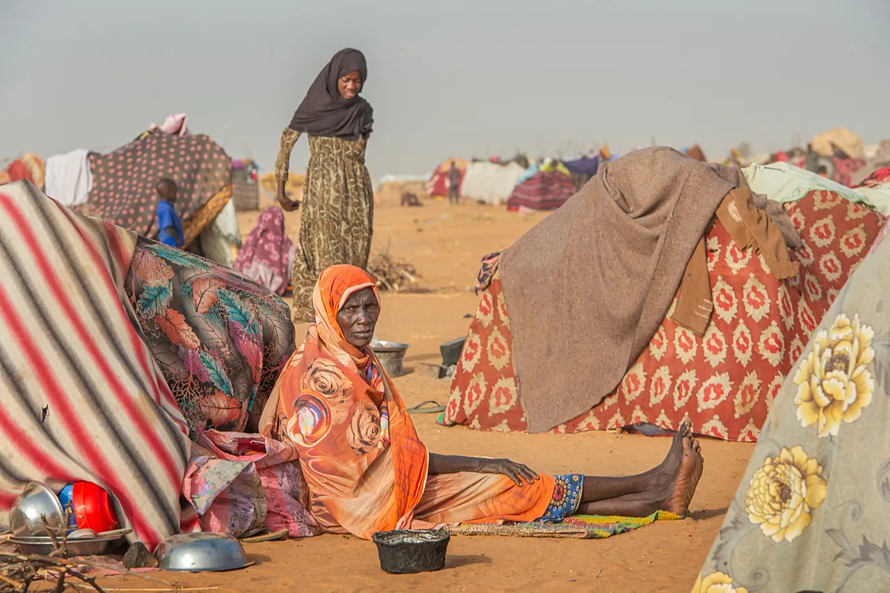 Une femme âgée se repose devant un abri de fortune. Les personnes âgées sont parmi les plus vulnérables, arrivant souvent après des jours de marche pour fuir la violence (janvier 2026).