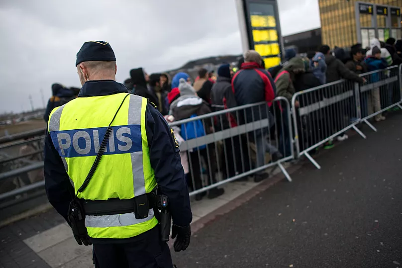 Un policier surveille une file de nouveaux arrivants au poste de Hyllie, le 19 novembre 2015.