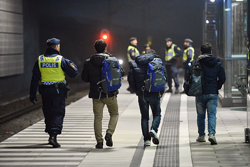 La police escorte trois hommes depuis un train à la gare de Hyllie, le 17 décembre 2015.