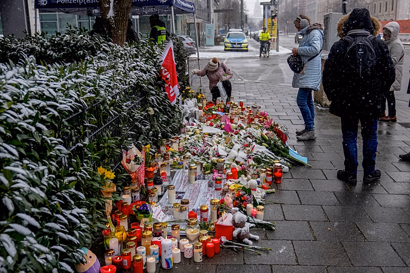 Des fleurs et des bougies ont été déposées près de l'endroit où une voiture a percuté un groupe de manifestants en février 2025, trois jours après l'attaque,