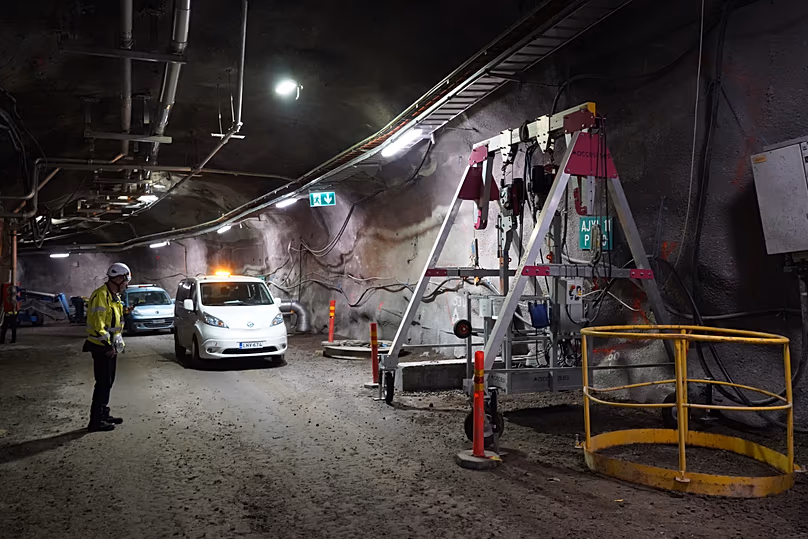 Un employé de Posiva se tient à côté de véhicules à l'intérieur d'un tunnel du dépôt de déchets nucléaires d'Onkalo, sur l'île d'Olkiluoto, en Finlande, le mardi 24 février 2026.