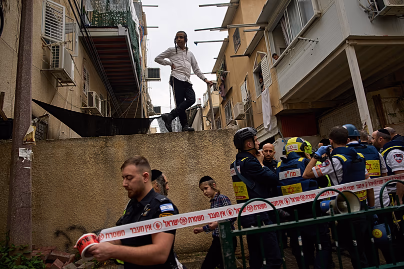 Les forces de sécurité israéliennes et des habitants inspectent un site touché par un missile iranien à Bnei Brak, le 1er avril 2026.