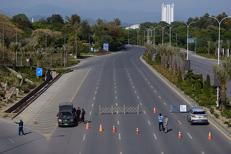 Des policiers montent la garde à un poste de contrôle sur une route barricadée pour assurer la sécurité avant le deuxième cycle de pourparlers américano-iraniens, à Islamabad, le dimanche 19 avril 2026.