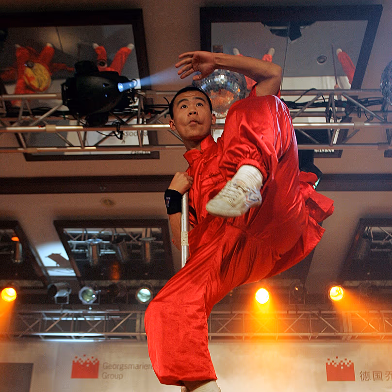 Un moine chinois pratique un art martial sur un poteau à Pékin