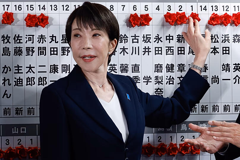 Le Premier ministre japonais Takaichi met des épinglettes sur les candidats qui ont remporté les élections à la Chambre basse, le 8 février 2026.