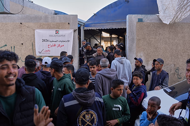 Des hommes palestiniens se rassemblent devant un bureau de vote pour participer aux élections locales à Deir al-Balah, dans le centre de la bande de Gaza, le samedi 25 avril 2026.