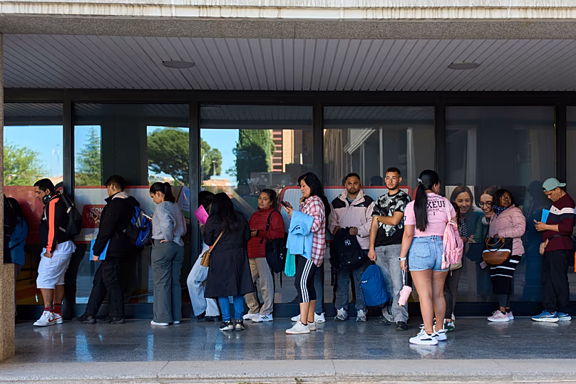 Des immigrants font la queue pour demander un certificat de transport public à Madrid, le 16 avril 2026