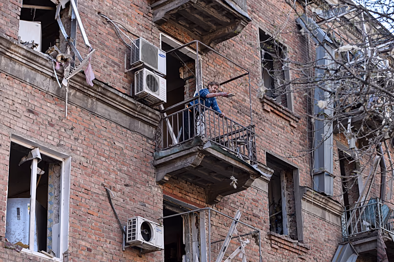 Une habitante débarrasse les décombres de son appartement dans un immeuble résidentiel endommagé par une frappe russe, à Dnipro, en Ukraine, le samedi 25 avril 2026.