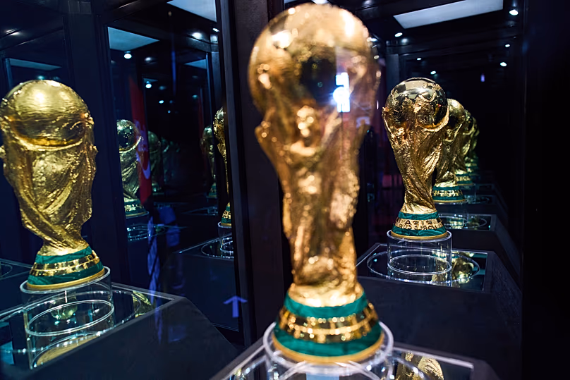 Le trophée de la Coupe du Monde de la FIFA se reflète dans différents miroirs lors d'une exposition à Buenos Aires, le 20 février 2026.