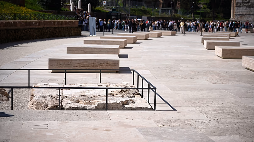 Des gens marchent dans le nouvel espace extérieur créé en marbre travertin autour du Colisée lors de son inauguration à Rome, le 17 mars 2026.