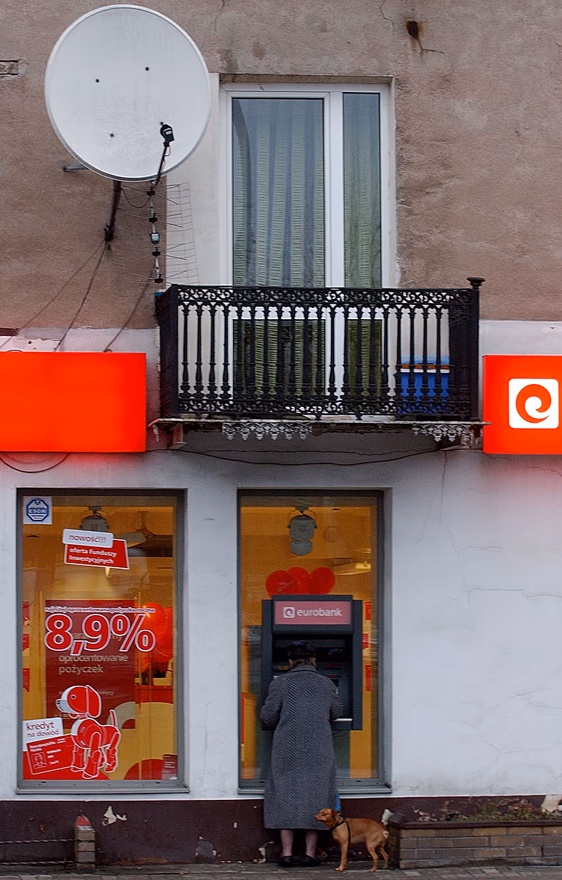 Une femme retire de l'argent à un distributeur automatique à Varsovie, le 14 décembre 2006.