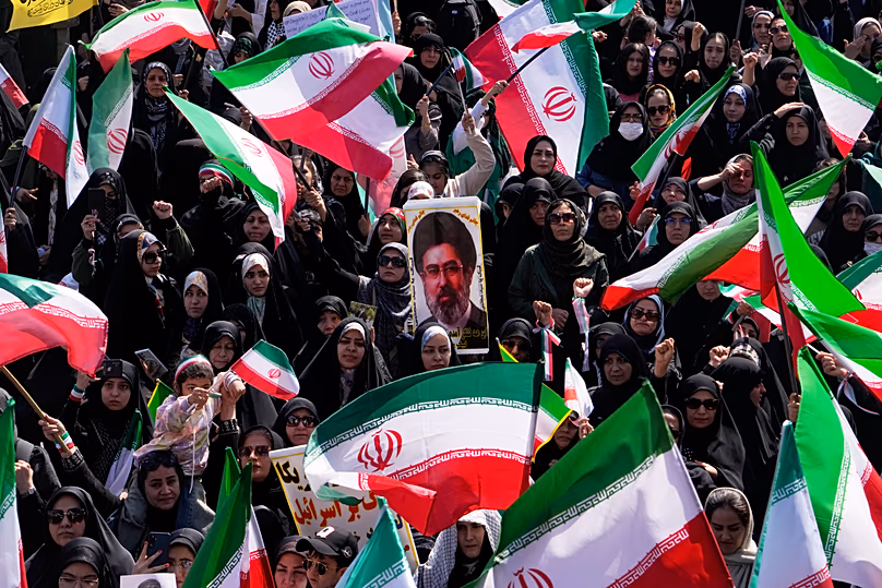Des femmes brandissent des drapeaux iraniens et un portrait du guide suprême, l'ayatollah Mojtaba Khamenei, lors d'un rassemblement à Téhéran, le 17 avril 2026.