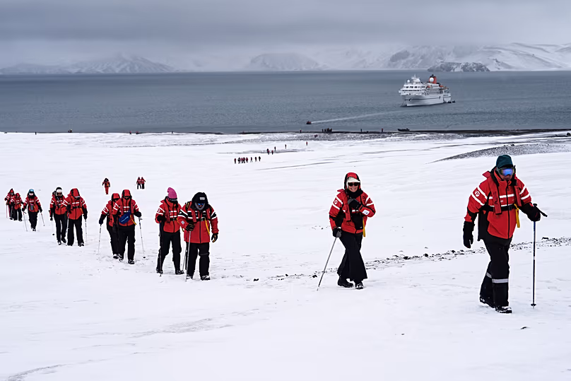 Des passagers marchent à l’intérieur du volcan de l’île de la Déception en Antarctique, le mercredi 26 novembre 2025.