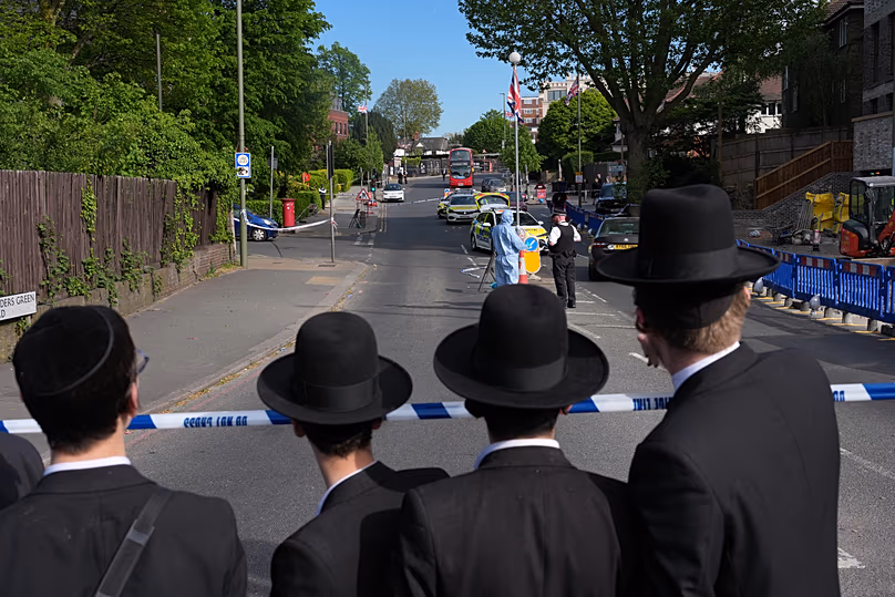 Des membres de la communauté regardent les policiers légistes fouiller le quartier de Golders Green, le 29 avril 2026.