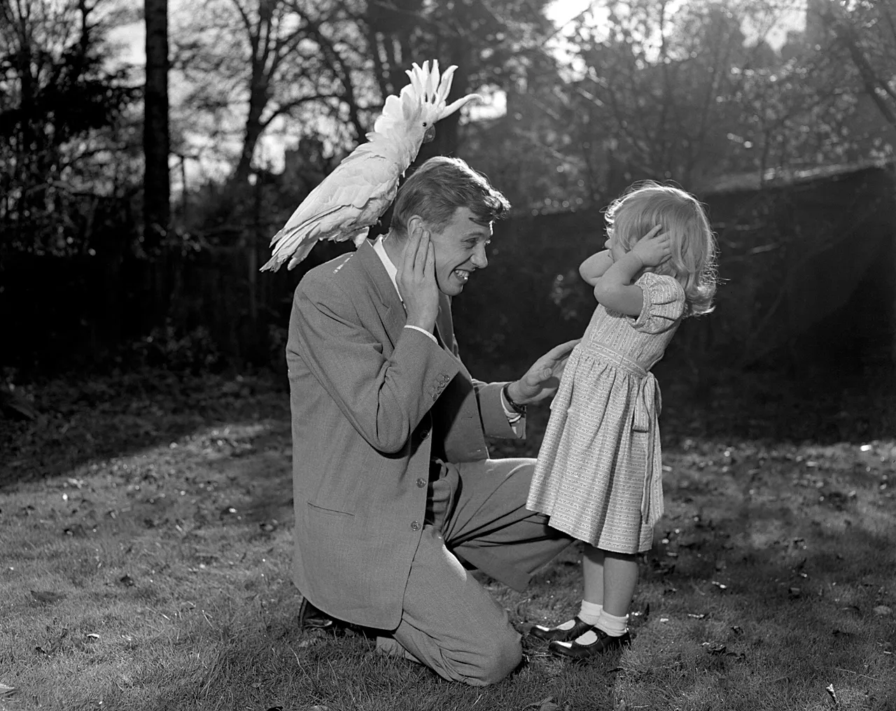 Susan, trois ans, et son père David Attenborough posent pour une photo avec un cacatoès à huppe jaune Georgie, le 7 décembre 1957.