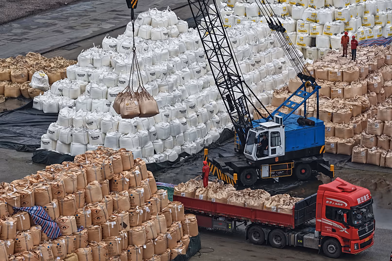 Des ouvriers transfèrent des sacs de soufre solide importé sur un camion dans un port de Nanjing, dans la province du Jiangsu, dans l'est de la Chine, le 14 avril 2026. (Chinatopix Via AP)